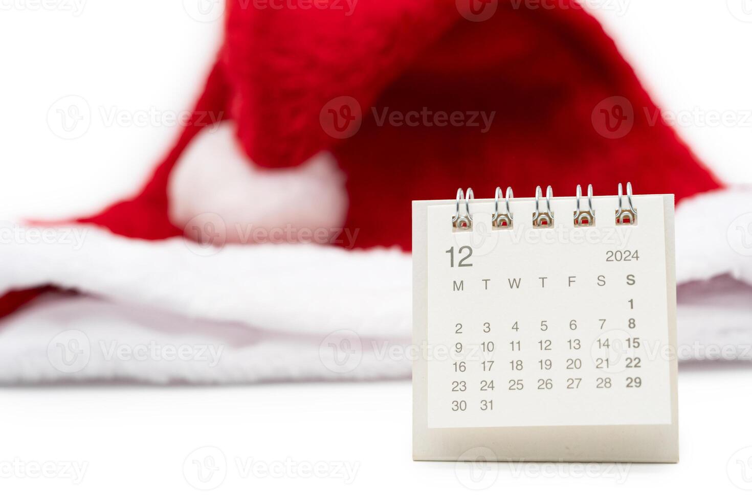 Simple desk calendar for DECEMBER 2024 with Santa hats on white background. New year Calendar concept with copy space. 2024 DEC calendar. photo
