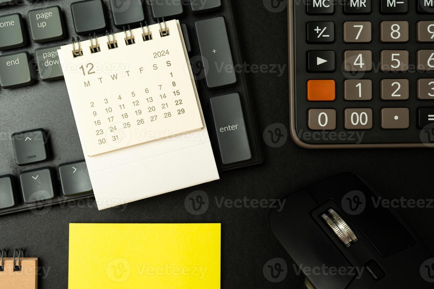 Simple desk calendar for December 2024 on desk and other supplies. photo