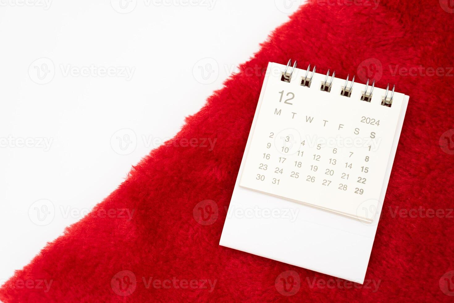 Simple desk calendar for DECEMBER 2024 with Santa hats on white background. New year Calendar concept with copy space. 2024 DEC calendar. photo