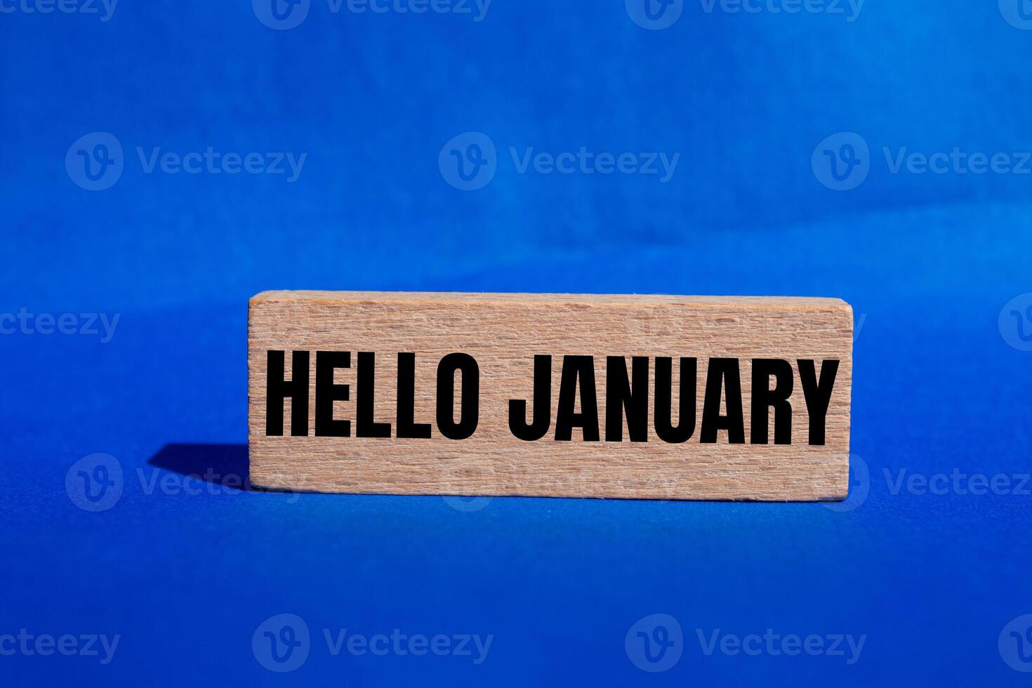 Hello january message written on wooden block with blue background. Conceptual hello january symbol. Copy space. photo