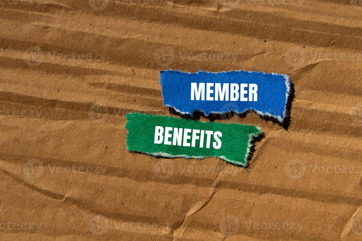 Member benefits message written on ripped torn paper pieces with cardboard background. Conceptual member benefits symbol. Copy space. photo