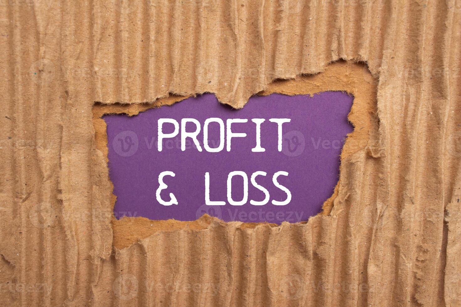 Profit and loss message written on ripped torn cardboard paper with purple background. Conceptual profit and loss symbol. Copy space. photo