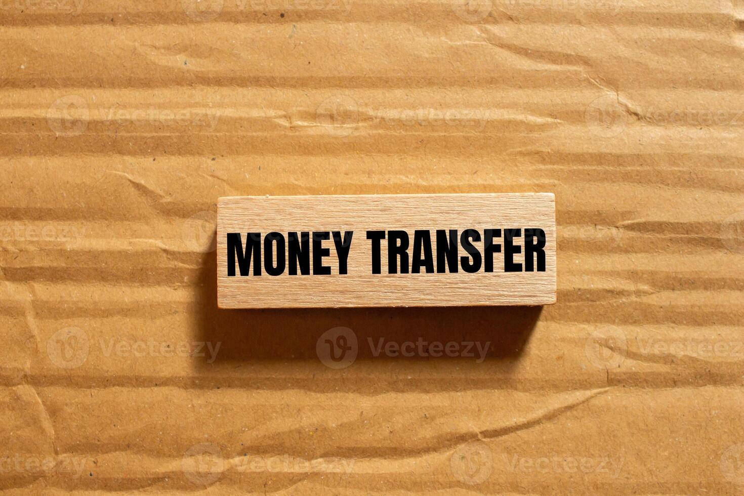 Money transfer message written on wooden block with cardboard background. Conceptual money transfer symbol. Copy space. photo