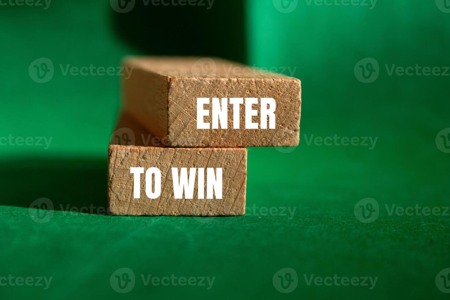 Enter to win message written on wooden blocks with green background. Conceptual enter to win symbol. Copy space. photo