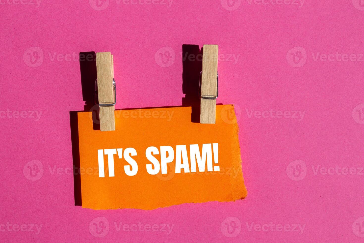 It's spam message written on ripped torn orange paper piece with pink background. Conceptual it's spam symbol. Copy space. photo