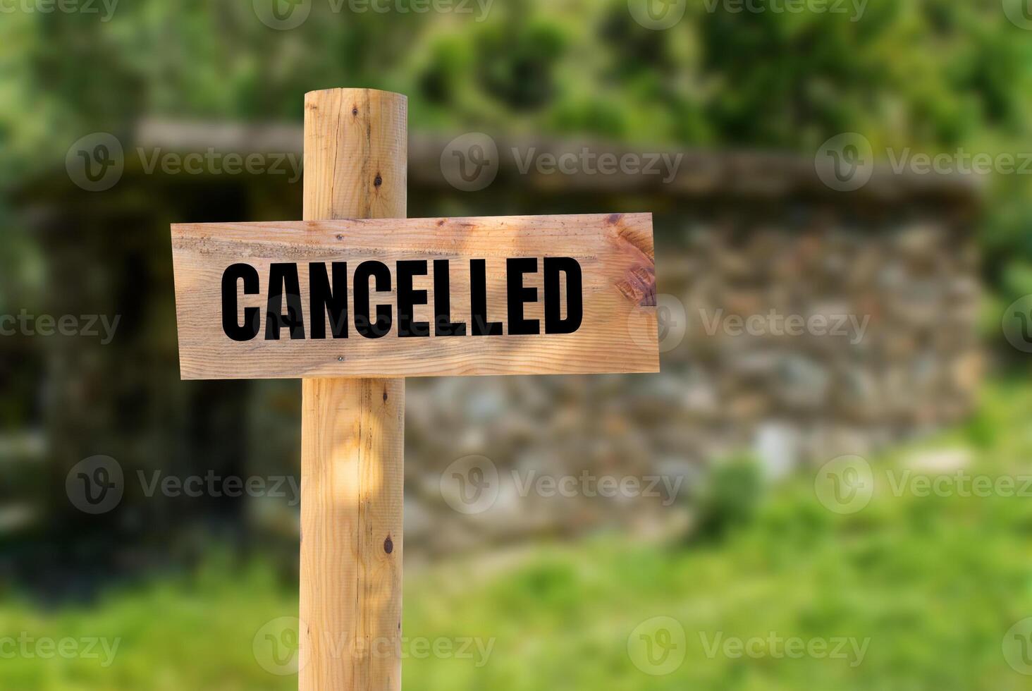 Cancelled message written on wooden sign with blurry nature background. Conceptual cancelled symbol. Copy space. photo