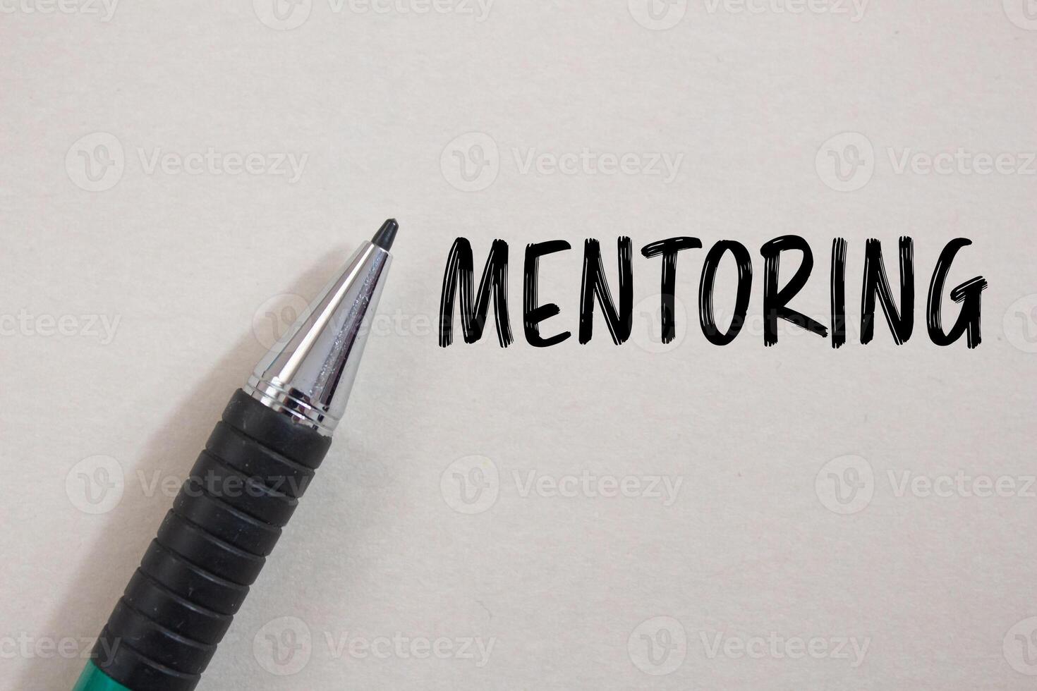 Mentoring message written on white paper with a pen. Conceptual mentoring symbol. Copy space. photo