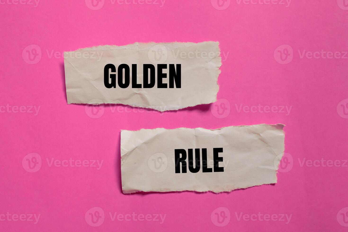 Golden rule message written on ripped paper pieces with pink background. Conceptual golden rule symbol. Copy space. photo