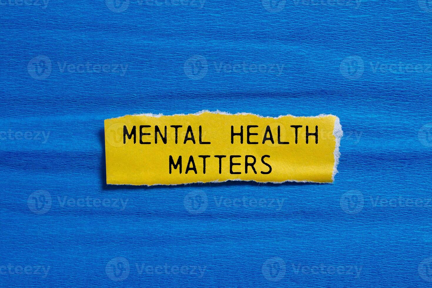 Mental health matters message written on ripped torn yellow paper piece with blue background. Conceptual mental health matters symbol. Copy space. photo
