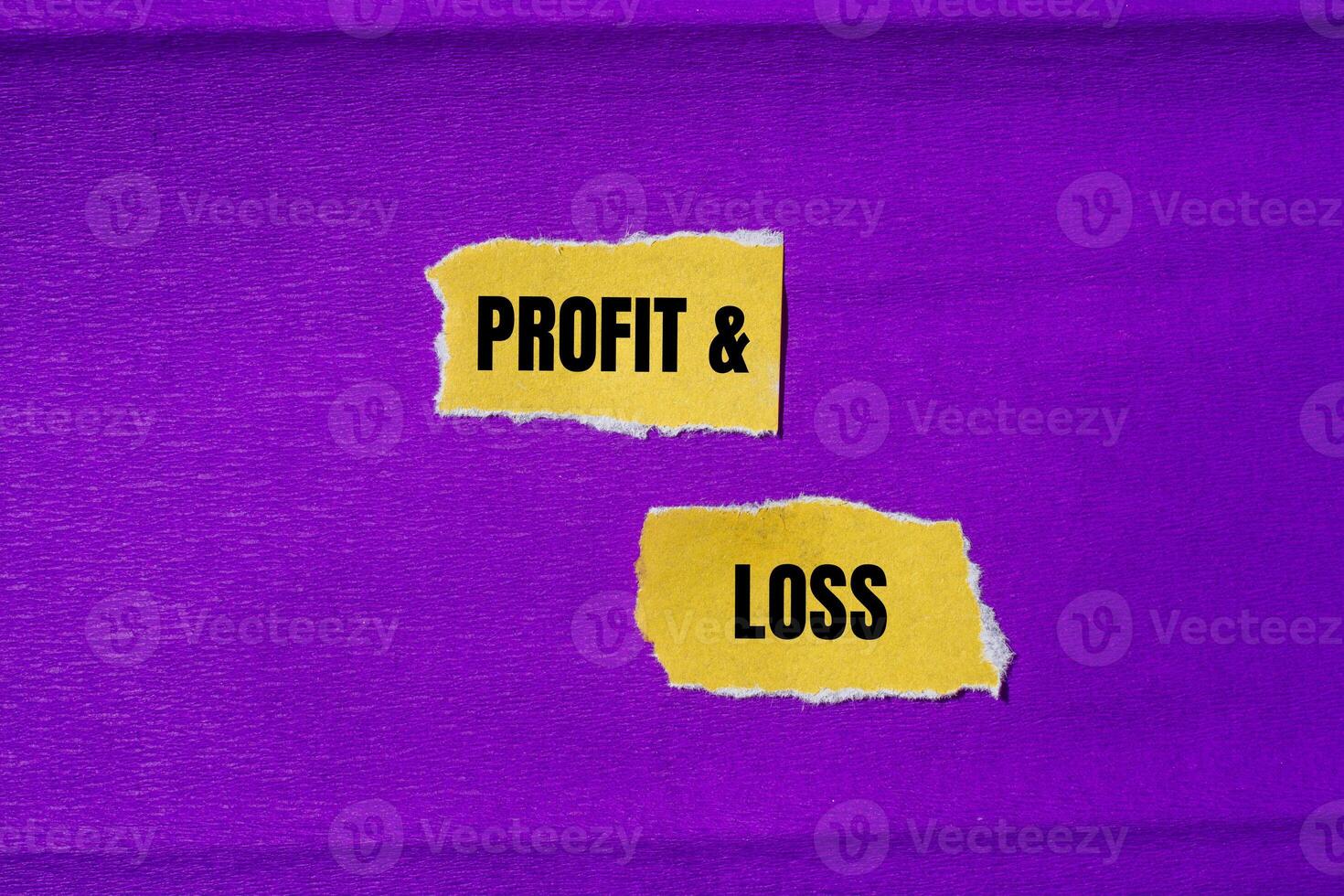 Profit and loss message written on ripped torn yellow paper pieces with purple background. Conceptual profit and loss symbol. Copy space. photo
