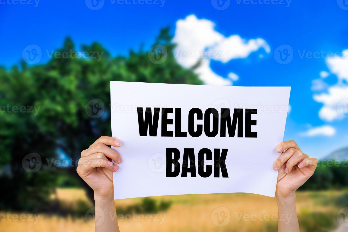 Welcome back message written on white paper with nature background. Conceptual welcome back symbol. Copy space. photo