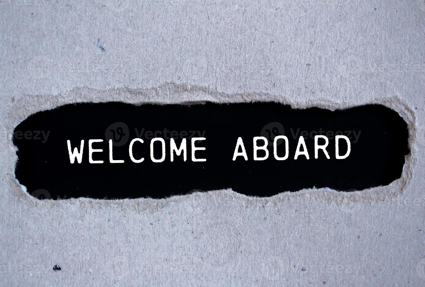 Welcome aboard message written on ripped torn gray paper with black background. Conceptual welcome aboard symbol. Copy space. photo
