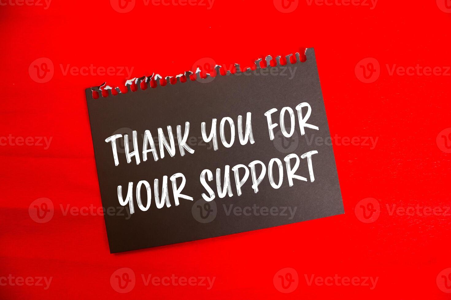 Thank you for your support message written on black paper with red background. Conceptual thank you for your support symbol. Copy space. photo