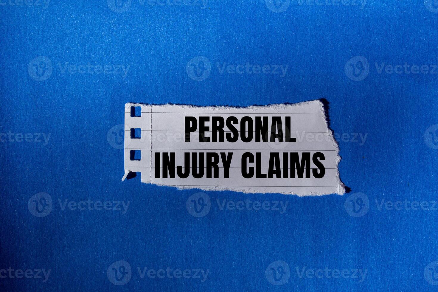 Personal injury claims message written on ripped torn paper piece with blue background. Conceptual personal injury claims symbol. Copy space. photo