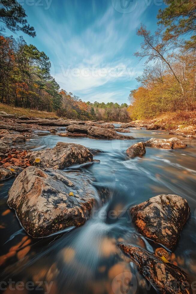 Wild mountain river flowing through rocks in autumn landscape photo