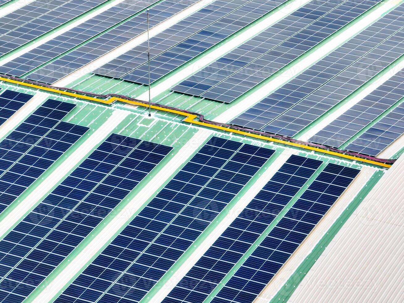 Solar energy for factory and warehouse building. Solar panels on roof of industrial plant. Commercial solar power. Rooftop solar power. Rooftop renewable energy system. Sustainable green energy. photo