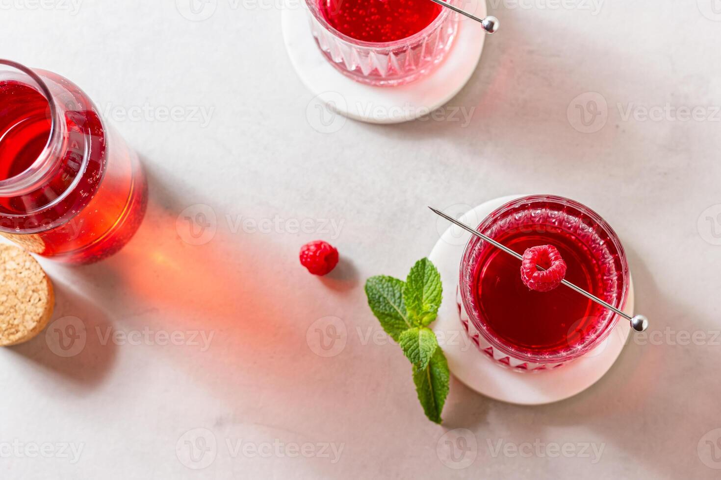 Raspberry cocktail in a glass on a marble stand photo