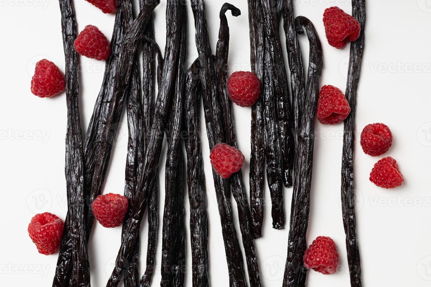 Vanilla beans with raspberries on white background photo