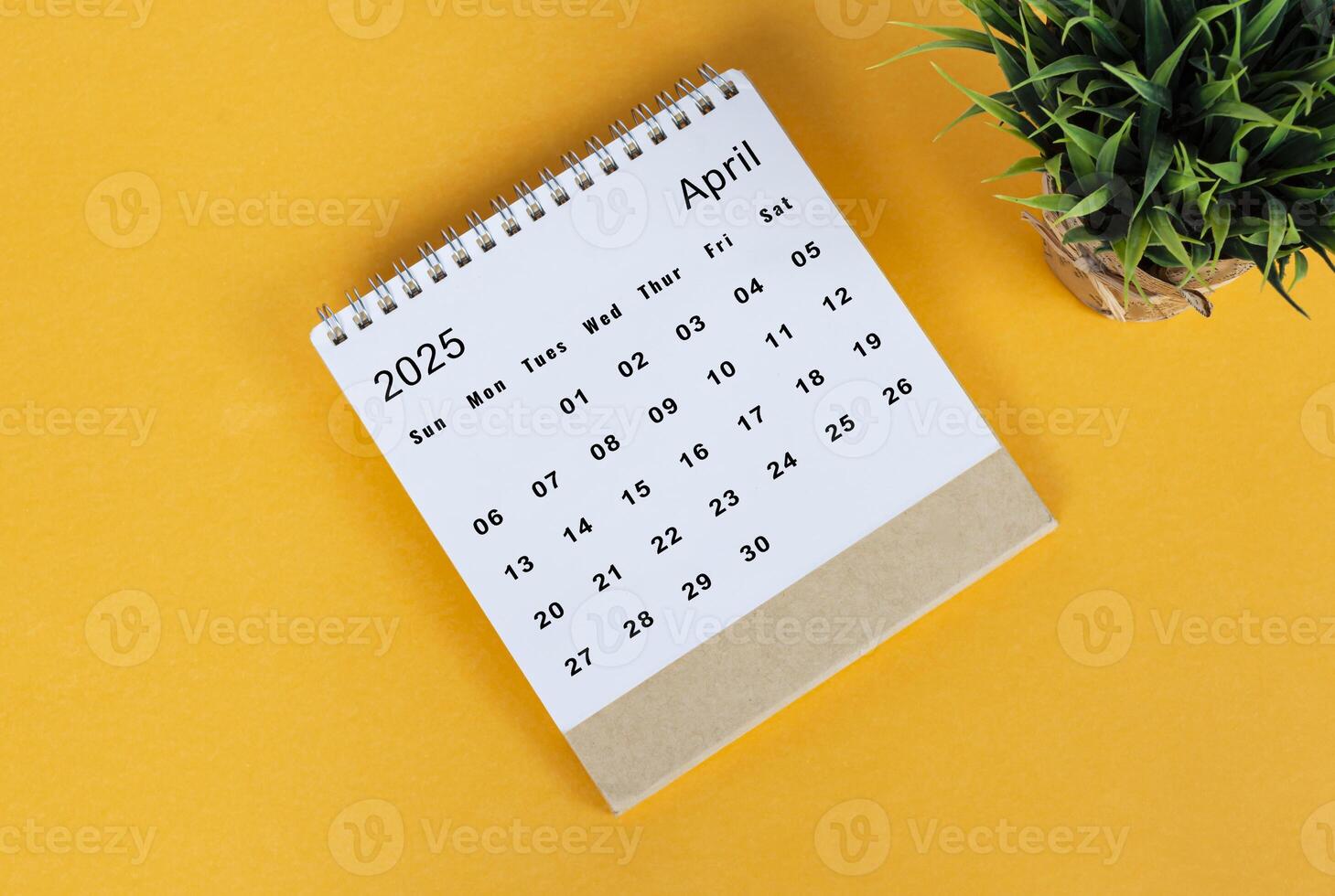 April 2025 desk calendar on yellow background. Directly above. Flat lay photo