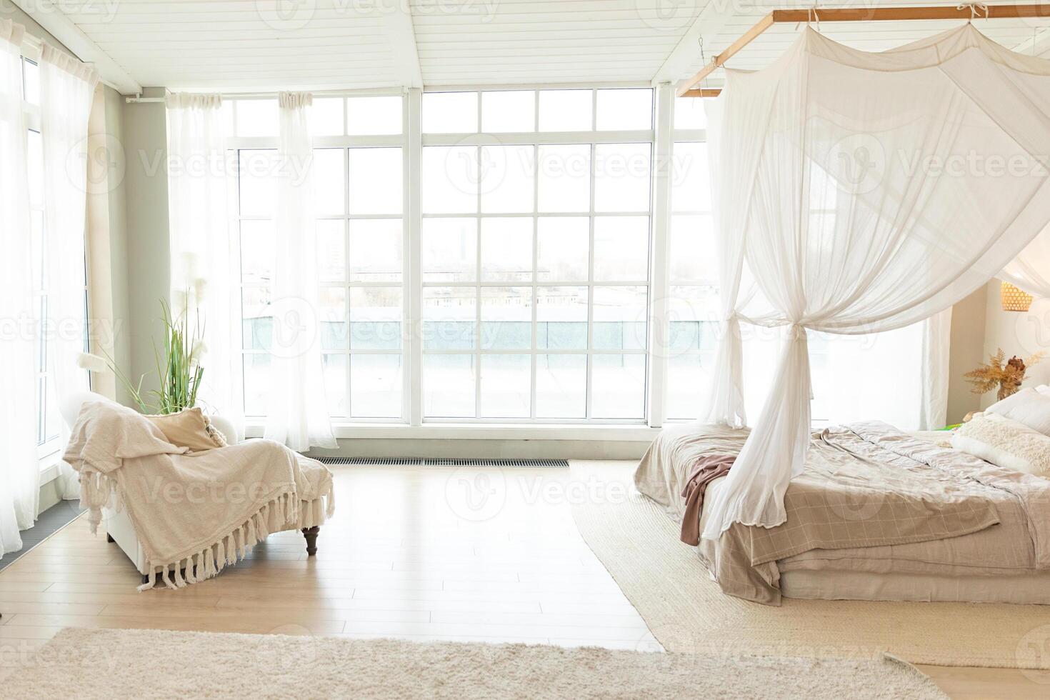Stylish loft bedroom interior. Spacious design apartment with light walls large windows big bed cozy chair. Clean modern decoration with elegant furniture in minimalist Scandinavian style photo