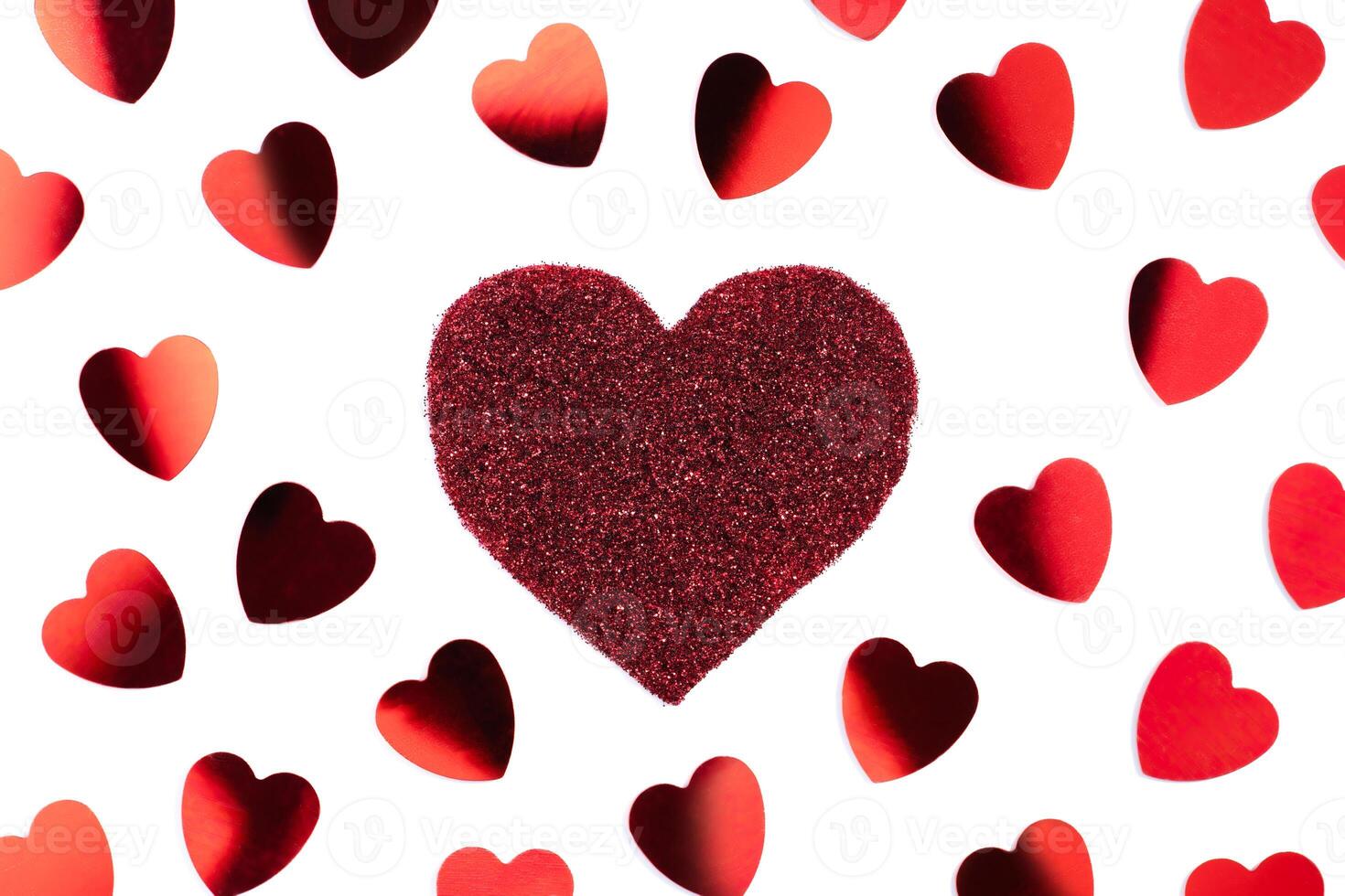Red sparkle glitter heart and confetti on white background. Minimalist holiday photo