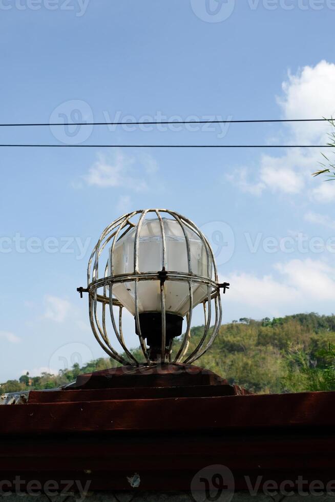 Round garden lights protected by iron frames. lights on the side of the road with a blue sky background. Copy Space. Graphic Resources. photo