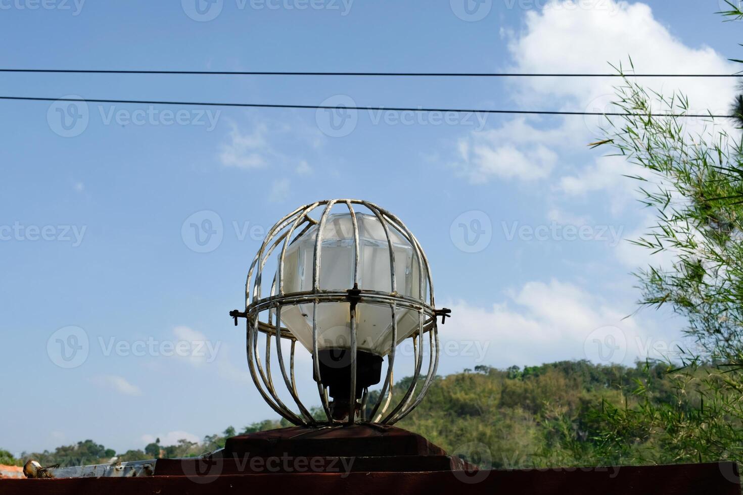 Round garden lights protected by iron frames. lights on the side of the road with a blue sky background. Copy Space. Graphic Resources. photo