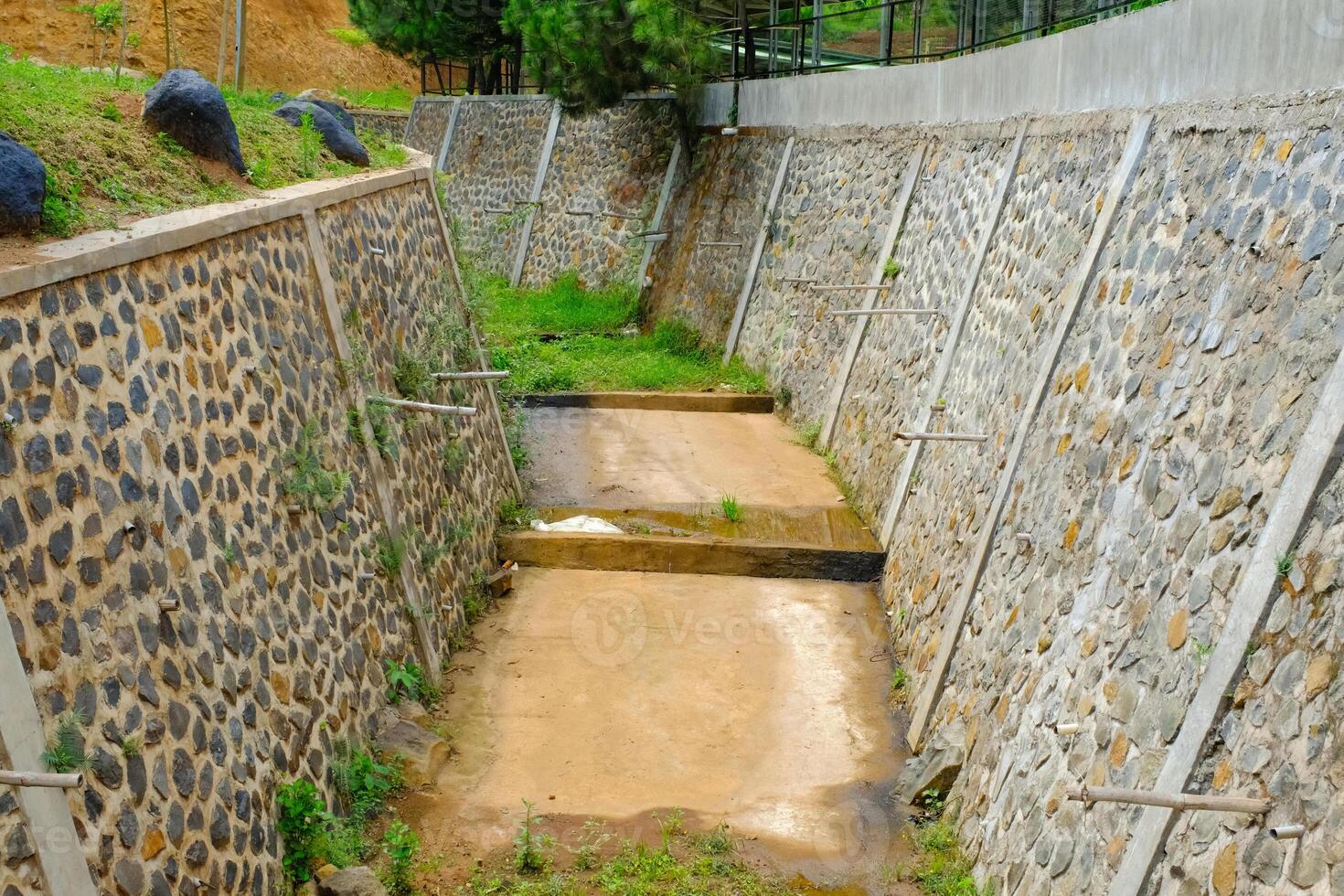 A water canal channel experiencing a water drought. Condition of the water canal during the dry season. Agricultural industry. Wallpaper Backgrounds. Textured Details. Drought strikes photo