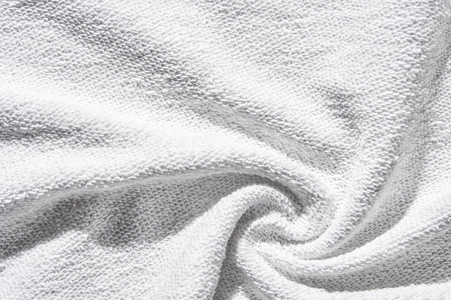 Soft white terry cloth fabric with textured surface and gentle folded swirl pattern for bath towels or robes. photo