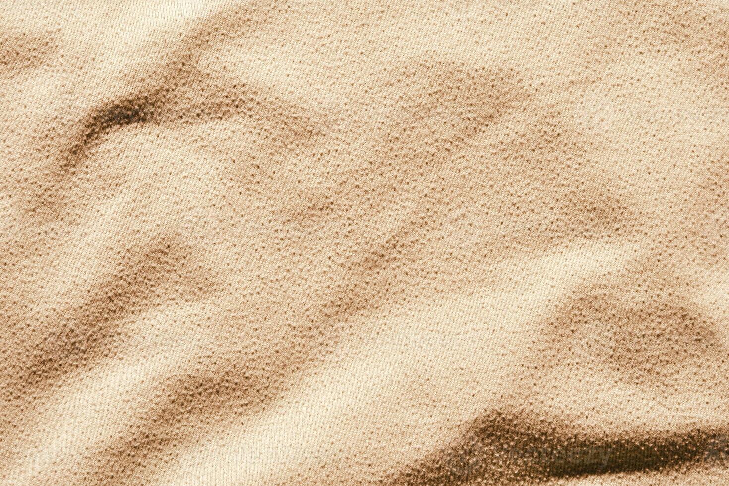 Close up texture of beige fabric with soft wavy patterns and shadow highlights. photo
