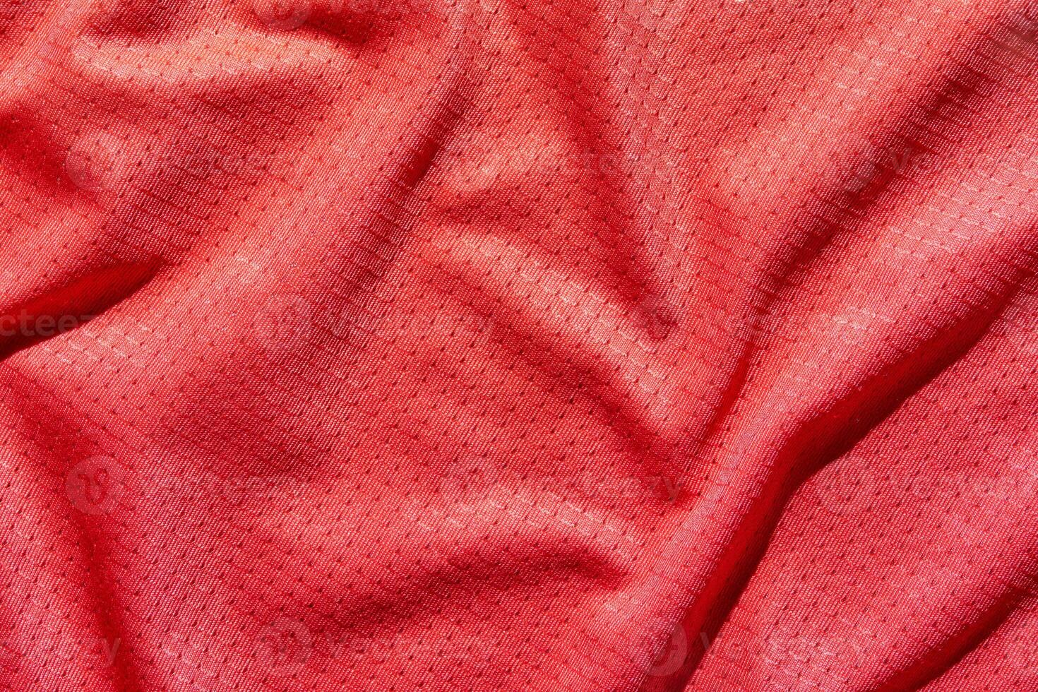 Texture of red fabric with subtle geometric patterns and soft drapery folds. photo