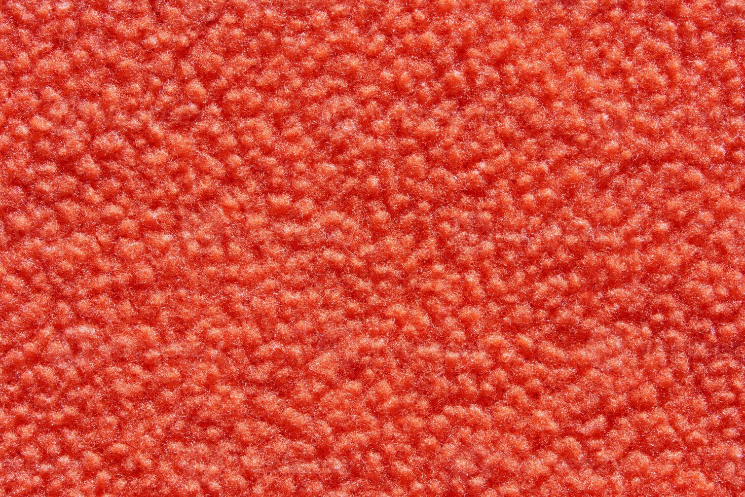 Red textured surface with soft fuzzy appearance and detailed fabric pattern. photo