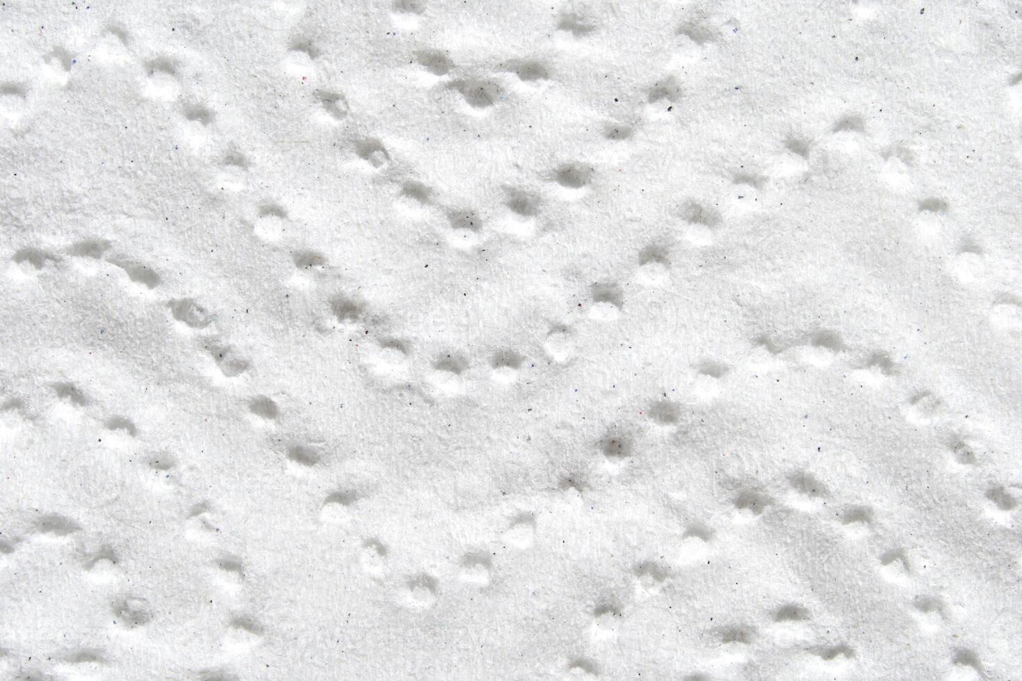 Abstract close up of white textured patterned surface with circular indentations. photo