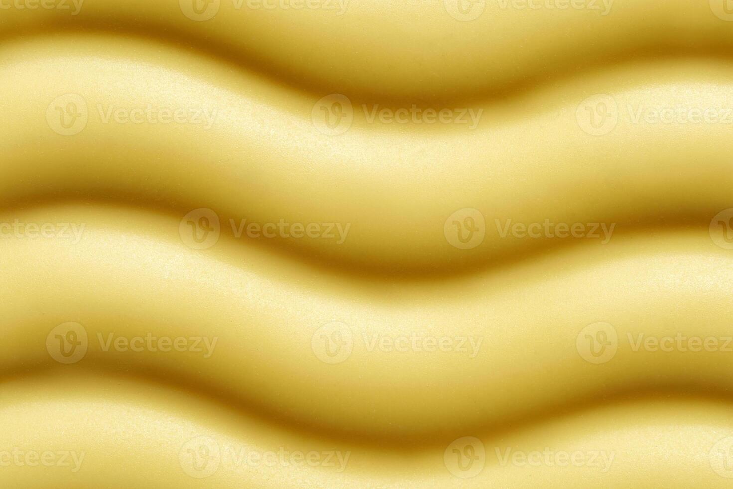Close up of wavy yellow foam texture in abstract pattern. photo