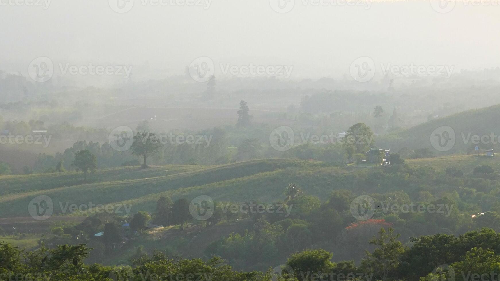Mountain valley with small house on the hill with mist photo