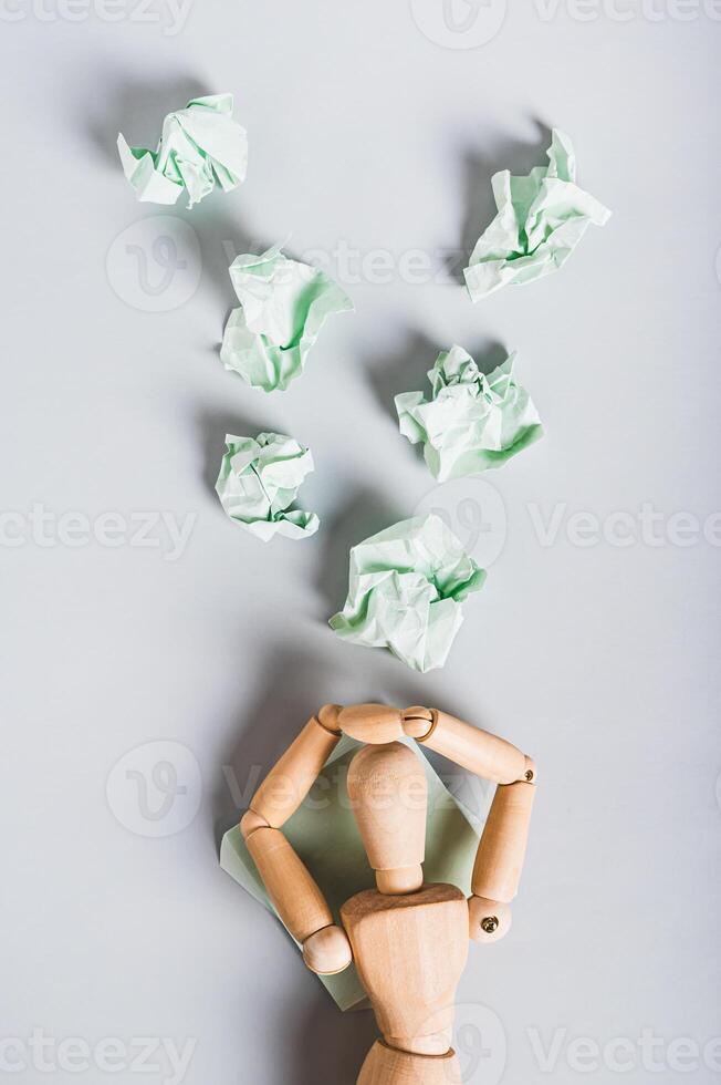 Crumpled note papers falling on burnt out man on light background top and vertical view photo