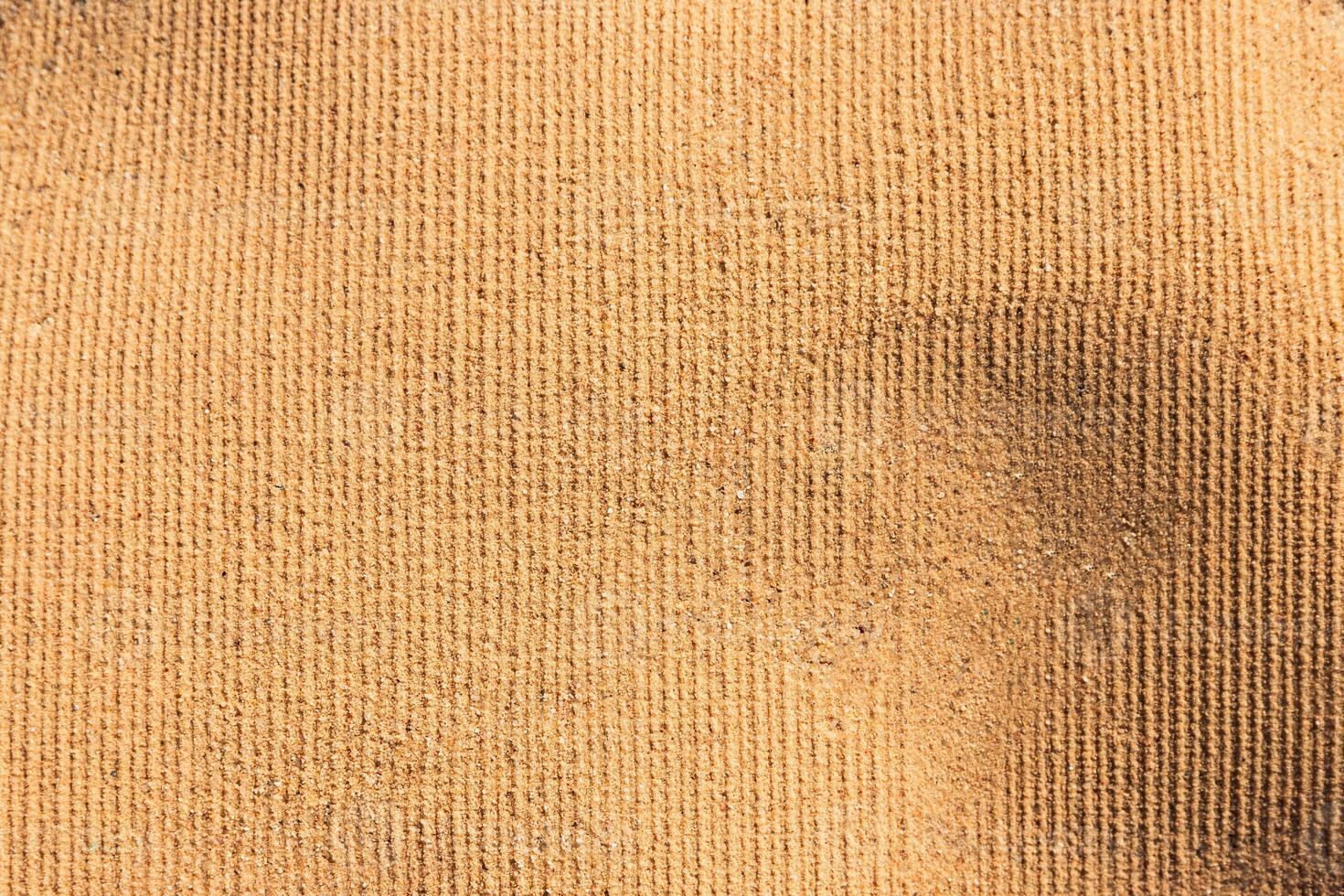 Beach towel imprint on sand. Sandy background. photo