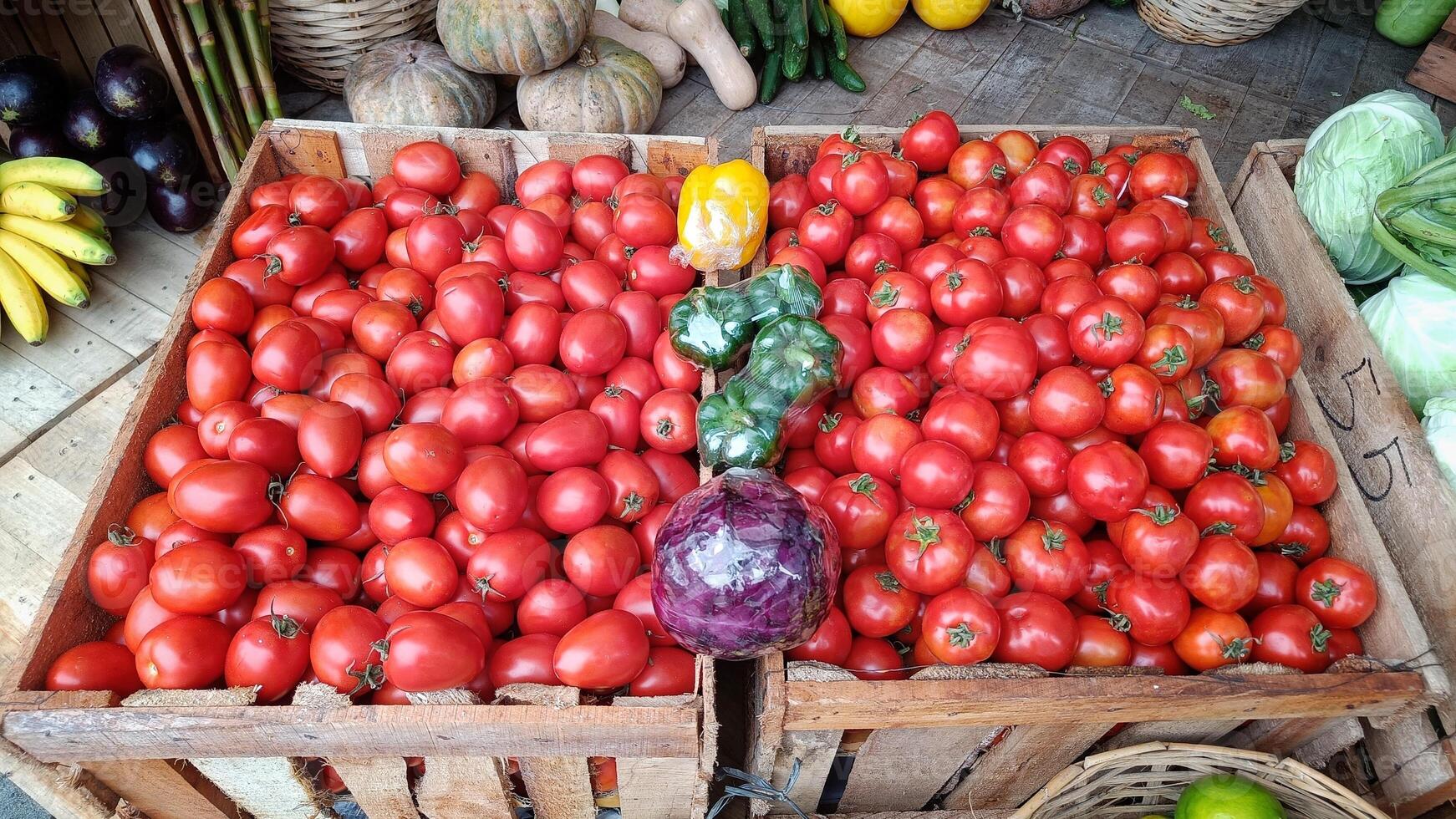 Close Up red fresh tomatoes in wooden crates for sale in a traditional market photo