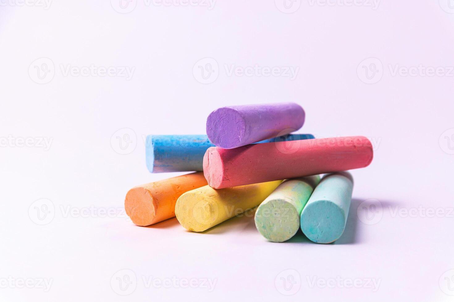 Crayons of different colors arranged on a white background. Education photo
