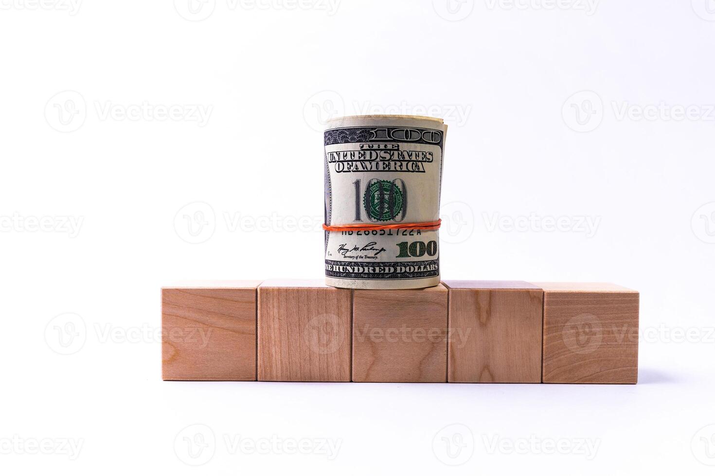 Wooden cubes in the form of steps rising upwards and a roll of American dollars. Financial pyramid. Copy space. photo