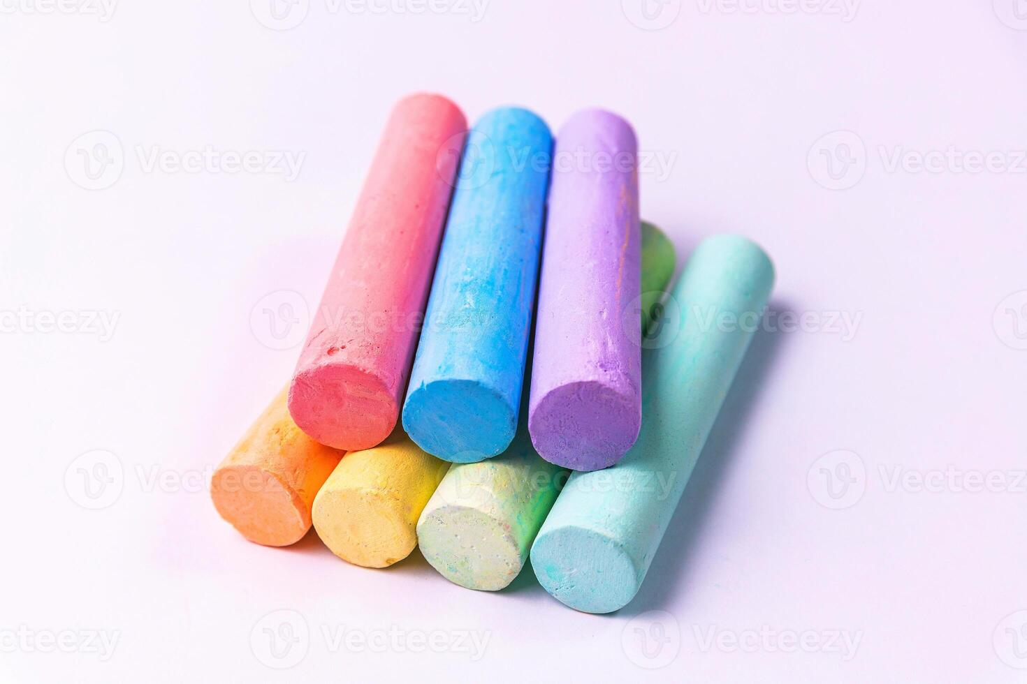 Crayons of different colors arranged on a white background. Education photo