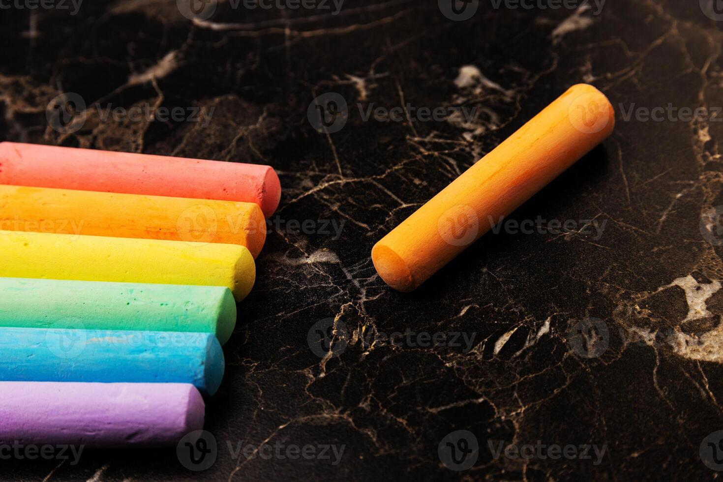 Crayons of different colors placed on a dark background. Education photo
