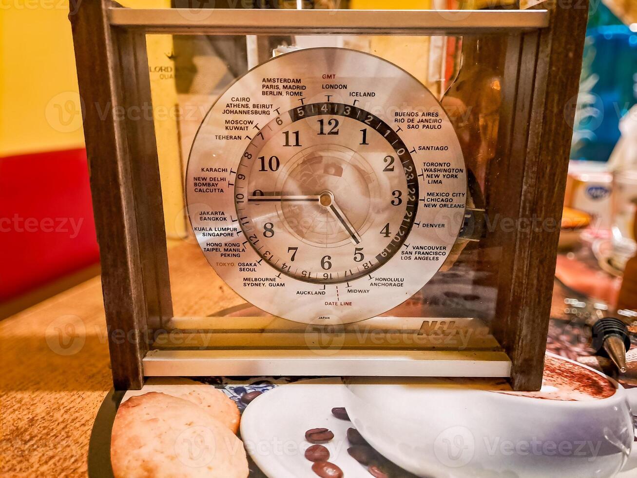 The dial of an old antique clock with the indicated hours in major cities world photo