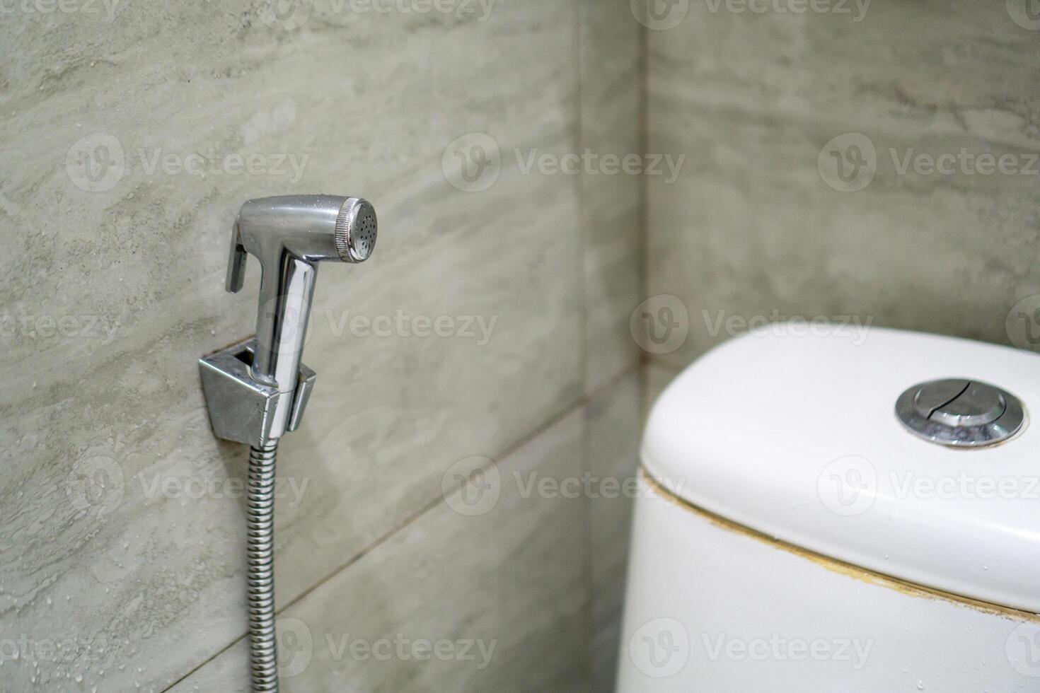Close up of chromium bidet shower in a toilet. Handheld bidet in bathroom. photo