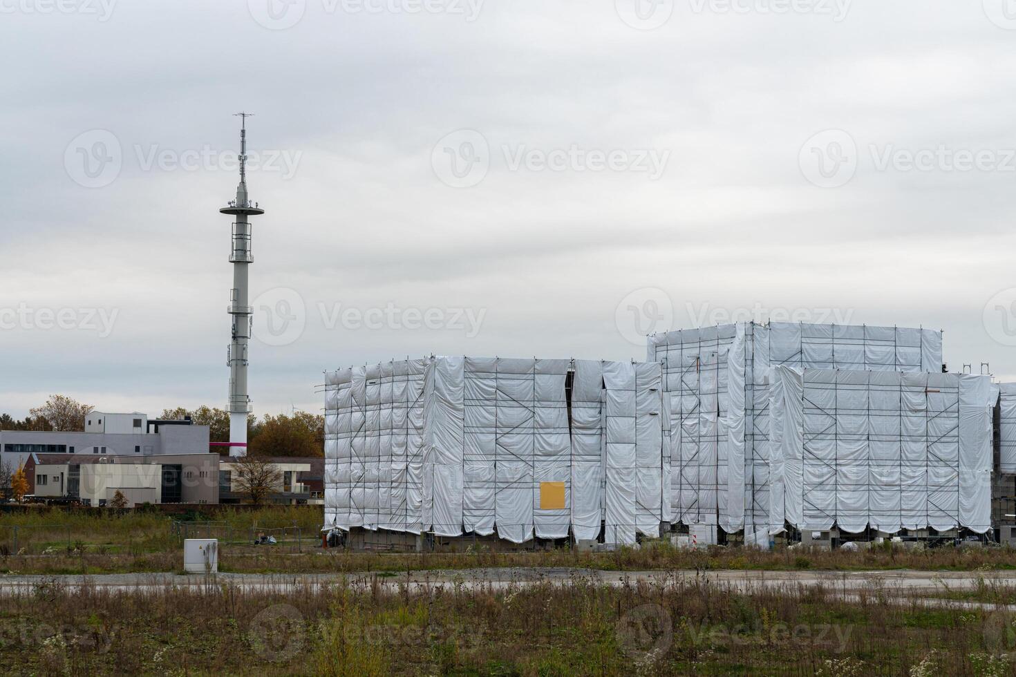 Construction site with covered structures near communication tower photo