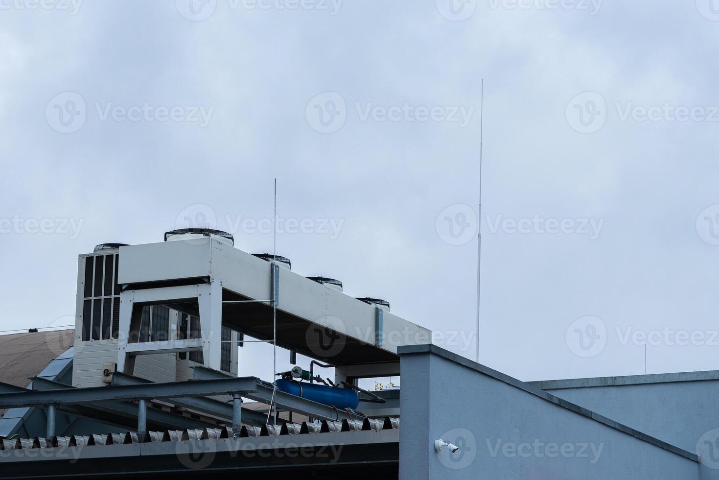 Rooftop cooling system and antennas overlooking a cloudy sky photo