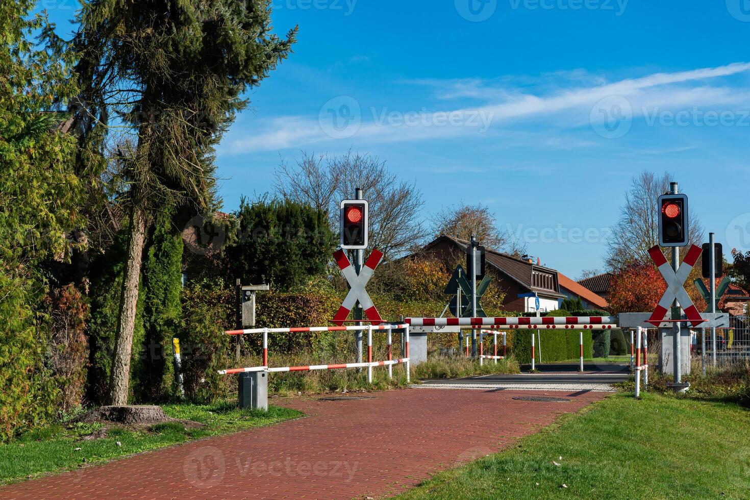 Railroad crossing gates with warning lights in a rural area photo