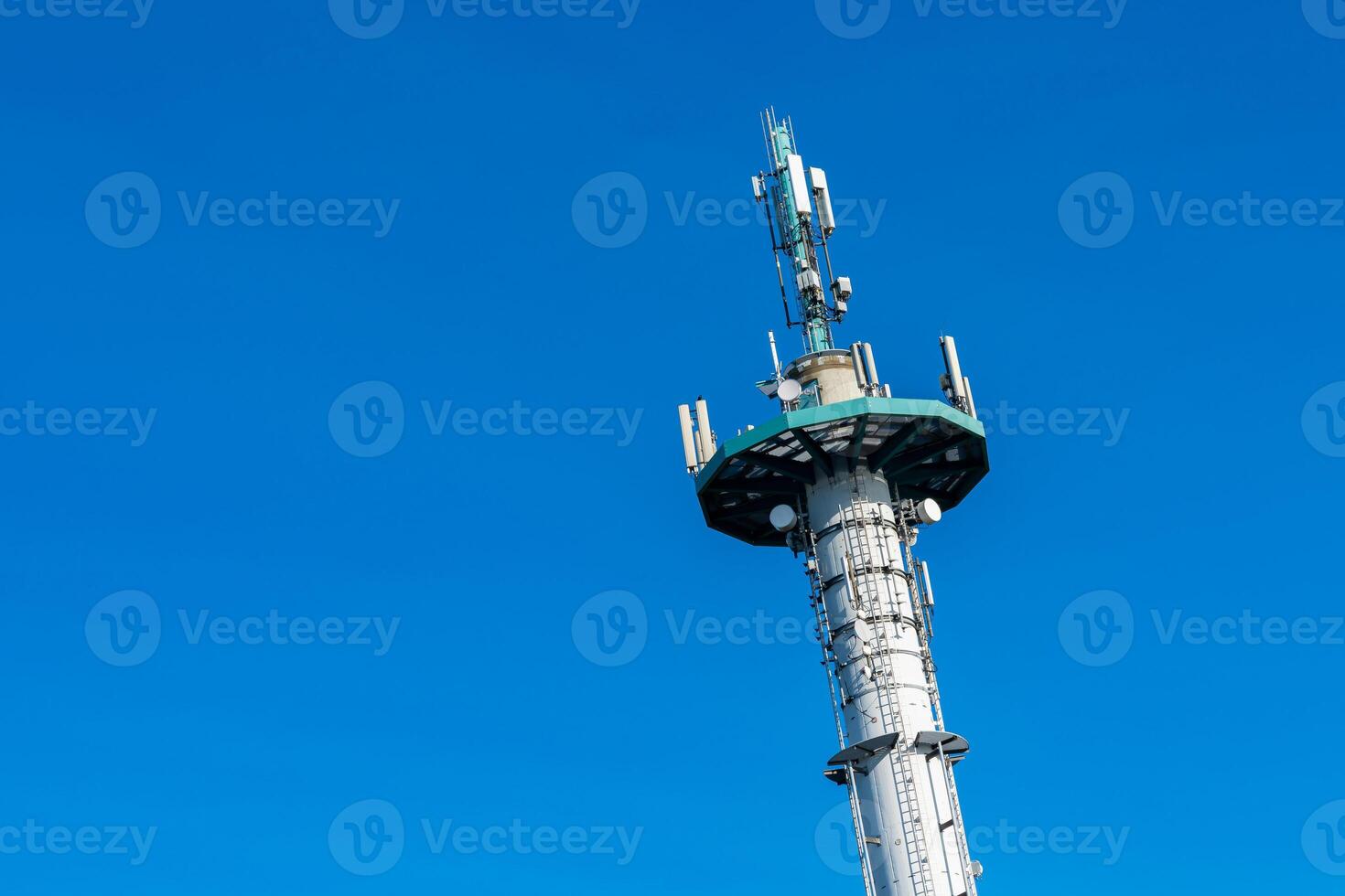 Communications tower standing against a bright blue sky photo