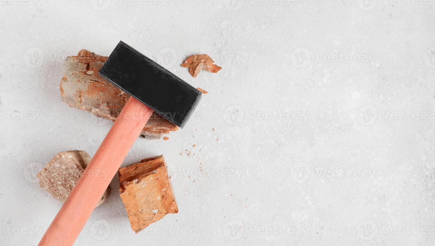 Sledgehammer construction tool on red bricks on concrete background, floor. Flat lay with copy space photo
