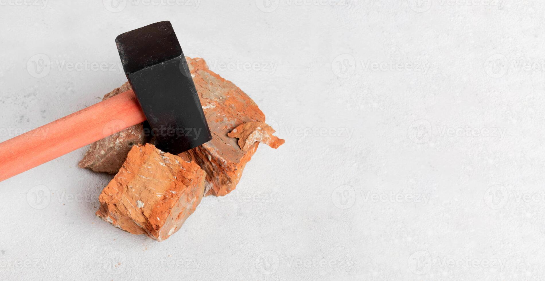 Building tool. c with a wooden handle on a concrete floor, background with broken red bricks photo